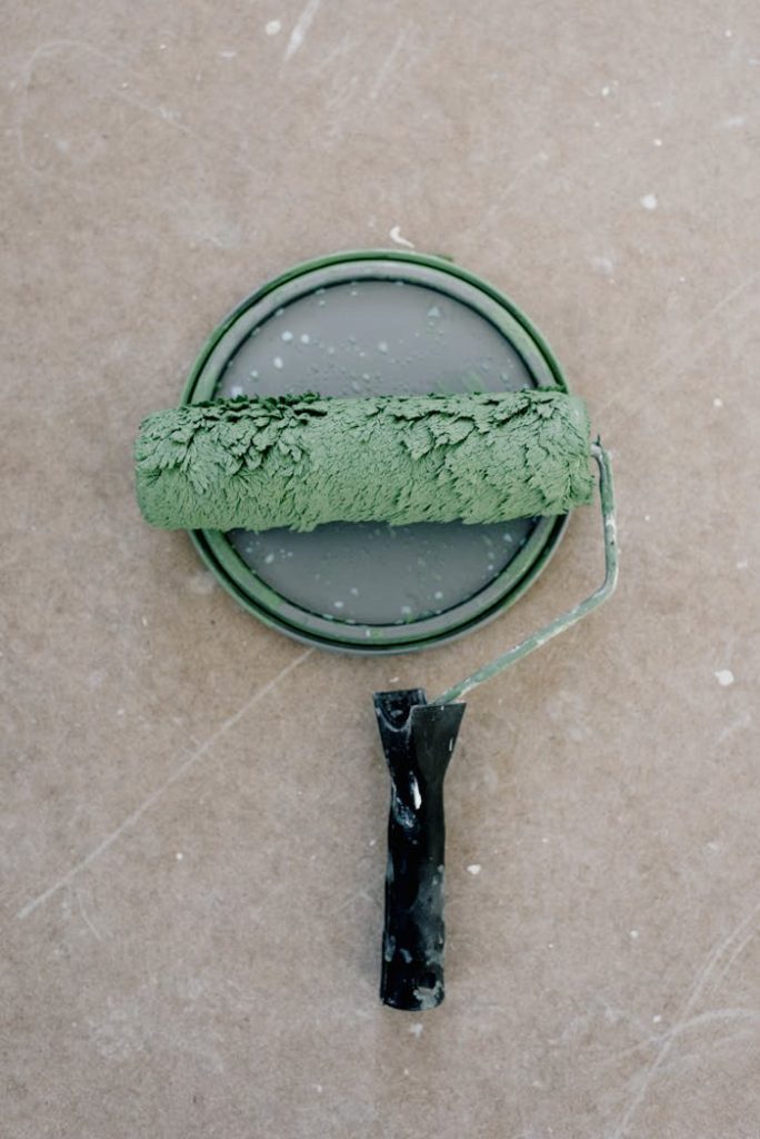 Close-up of a green paint roller atop a paint can, ideal for DIY and renovation themes.